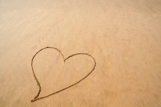 Heart drawn in the smooth beach sand for romantic Valentines day celebration