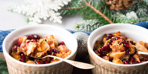 Christmas baked apple dessert with pomegranate seeds. Winter holidays treat on textured background. Banner