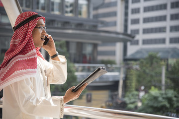 Smart handsome arab businessman using mobile phone in the city.