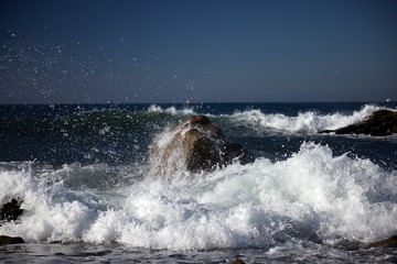 splits waves against rocks in the sea