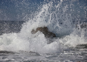 Obraz premium splits waves against rocks in the sea