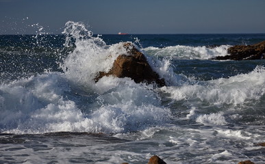 splits waves against rocks in the sea
