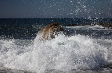 splits waves against rocks in the sea