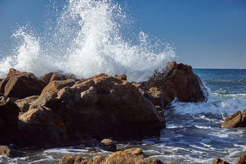 splits waves against rocks in the sea
