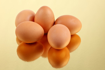 Brown eggs on gold reflective base
