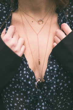 fashion blogger wearing a v-neck see through shirt and a beautiful and trendy golden chain necklace. detail shot of a perfect fall outfit accessories

