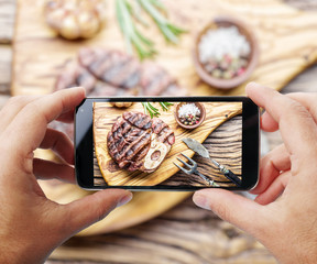 Taking photo of beef steak by smartphone.