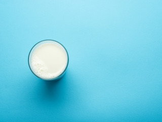 Glass of milk on the blue background. Top view.