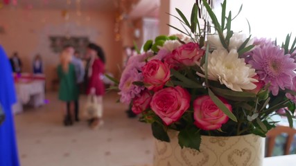bouquet of flowers is in the restaurant in flower the background are people