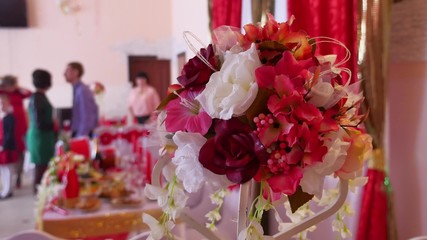 bouquet of flowers is in restaurant in the background are people