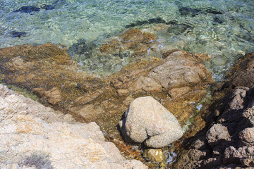 In Sardegna mare e cielo, acqua e rocce, acqua limpida, sole sull'isola. 

