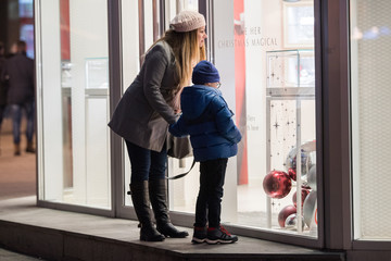 Young woman and her child looking at shop window