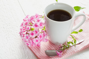 Morning coffee or cup of tea with pink flowers.