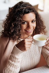 Charming African American woman enjoying the cup of tea