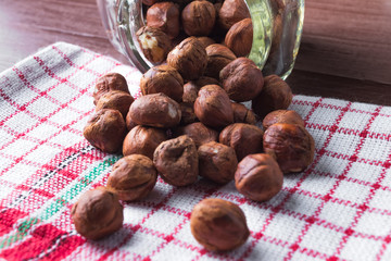 Hazelnuts in a jar on a vintage kitchen dishcloth.