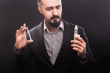 vaping man holding a mod and tobacco cigarette. Health concept