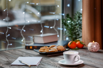 A cup of hot coffee on wooden table in cafe, close up view