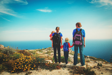 family with two kids hiking in summer mountains