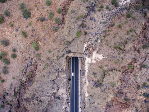 Aerial view of car entering mountain tunnel