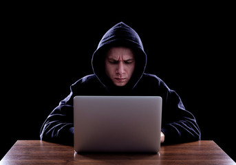 Hooded computer hacker stealing information