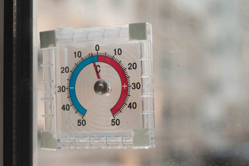 Naklejka premium the thermometer outside the window, frost on the yard