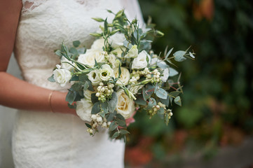 Obraz na płótnie Canvas bride holding a beautiful wedding bouquet of white roses