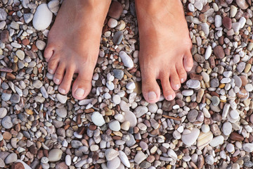 Barefoot woman standing on the pebbles or stones