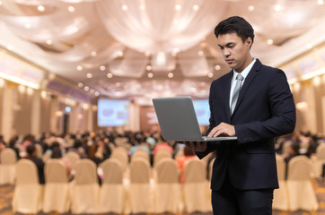 Businessman using the laptop on the Abstract blurred photo of co