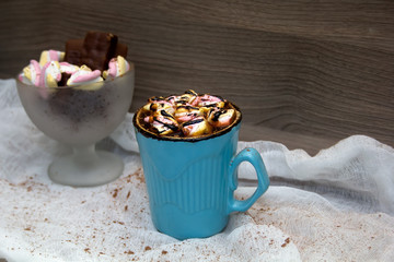 cocoa with marshmallows in  blue mug and chocolates