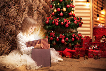 Obraz na płótnie Canvas little girl opens magic Christmas gift box 