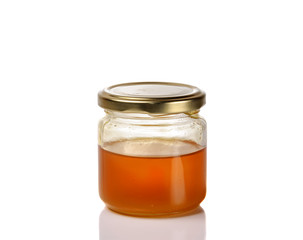 Jar of light golden honey isolated on a white background