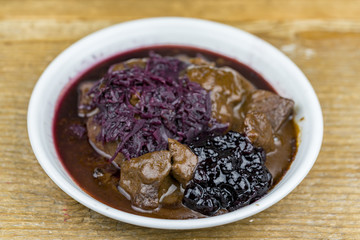 Close up view of a stew with red cabbage and cranberry sauce