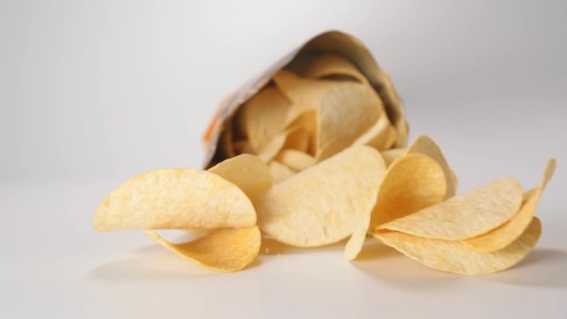 SLOW MOTION: Package falls and potato chips fall out from it