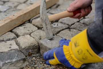 Handwerker legt Pflastersteine