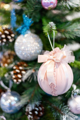 Christmas tree with colorful ornaments, textile pink and blue toys, shallow depth of field