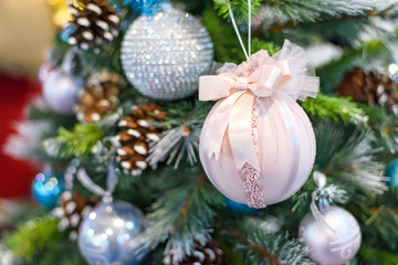 Christmas tree with colorful ornaments, textile pink and blue toys, shallow depth of field