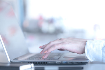 Female hands typing on a laptop