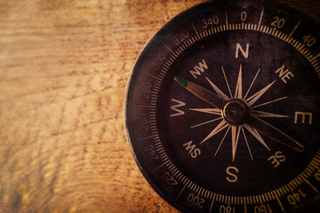 Fototapeta na wymiar compass on wooden table in vintage style for background