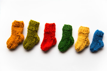 Small, hand knitted woolen socks on light background