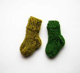 Small, hand knitted woolen socks on light background
