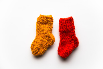 Small, hand knitted woolen socks on light background