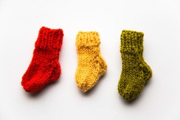 Small, hand knitted woolen socks on light background