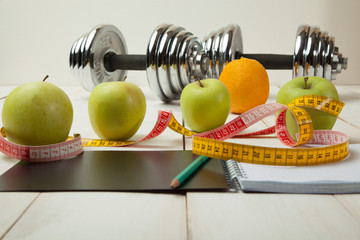 diet plan, menu or program, weight loss, measuring tape, dumbbells and dietary food fresh fruit