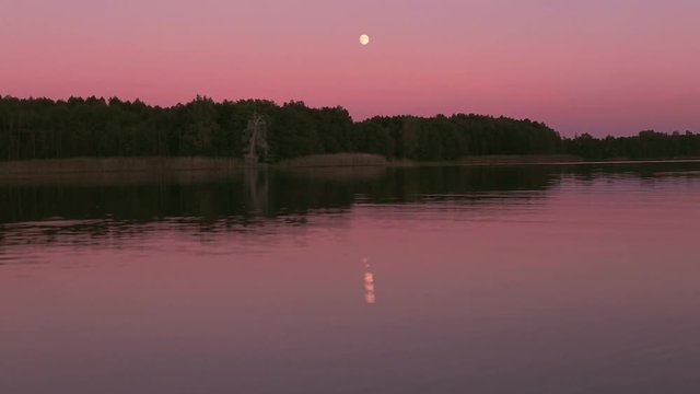 Full moon reflecting in a lake.