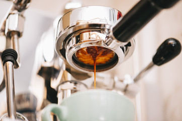 Fresh morning espresso coffee pouring through the bottomless portafilter