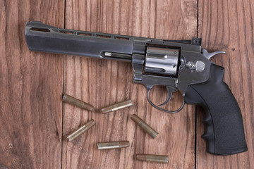 revolver gun and bullets on the wooden table