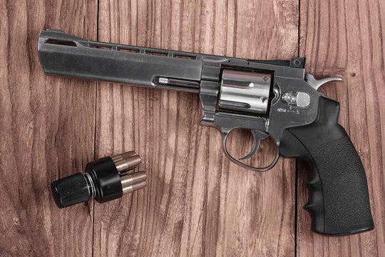 revolver gun and bullets on the wooden table