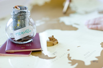 Naklejka na ściany i meble Travel budget - vacation money savings in a glass jar on world m