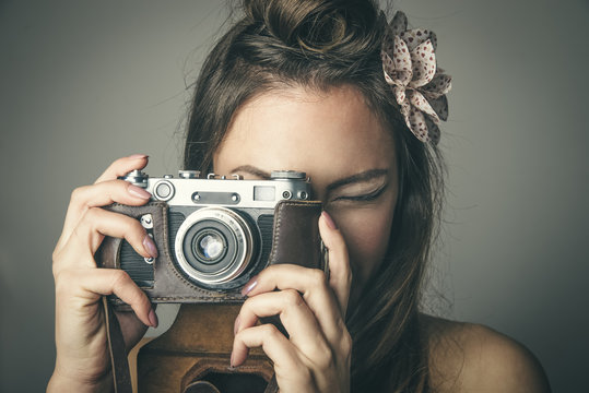 Young woman taking pictures with vintage camera