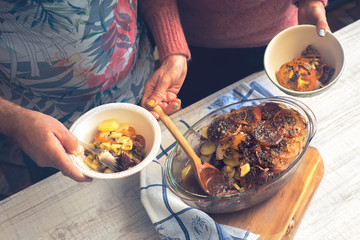 Putting baked meat with vegetables on the plate top view